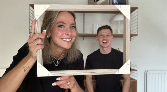 Co-Founders of Plan, Emmi and Ewan holding a custom Plan Frame