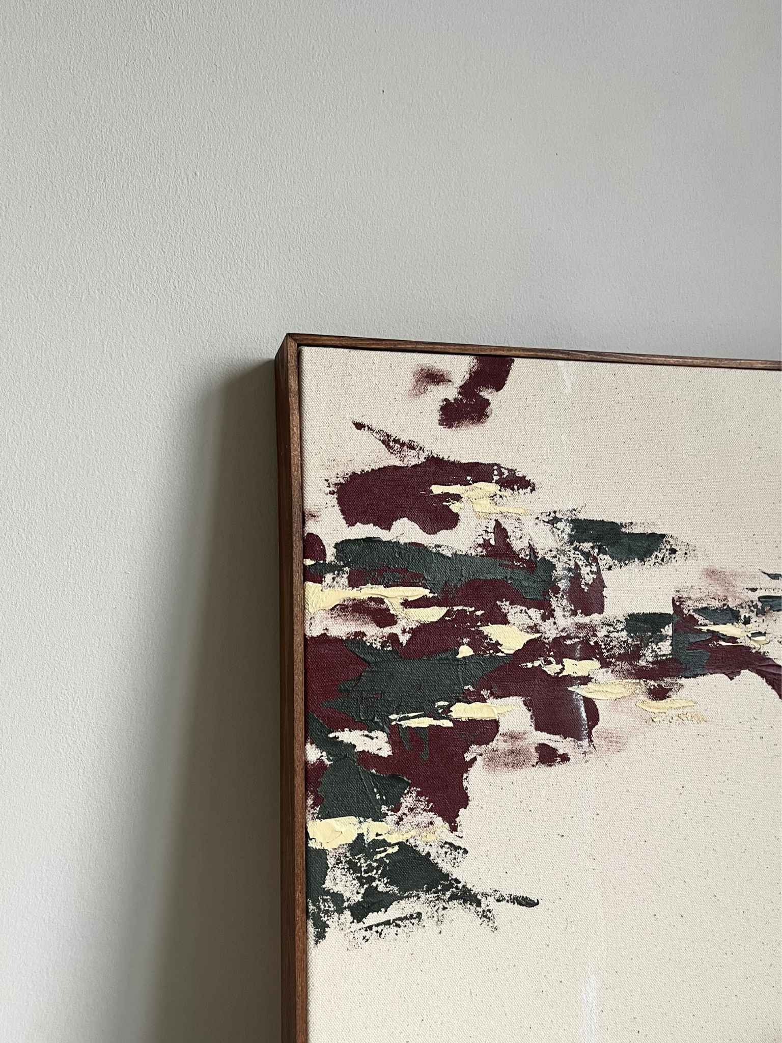 Minimal abstract framed canvas artwork made using the Plan Forest Red art kit, showing layered painterly marks in forest red, charcoal green and warm neutral tones on cotton canvas, finished with a handcrafted wooden edge frame.