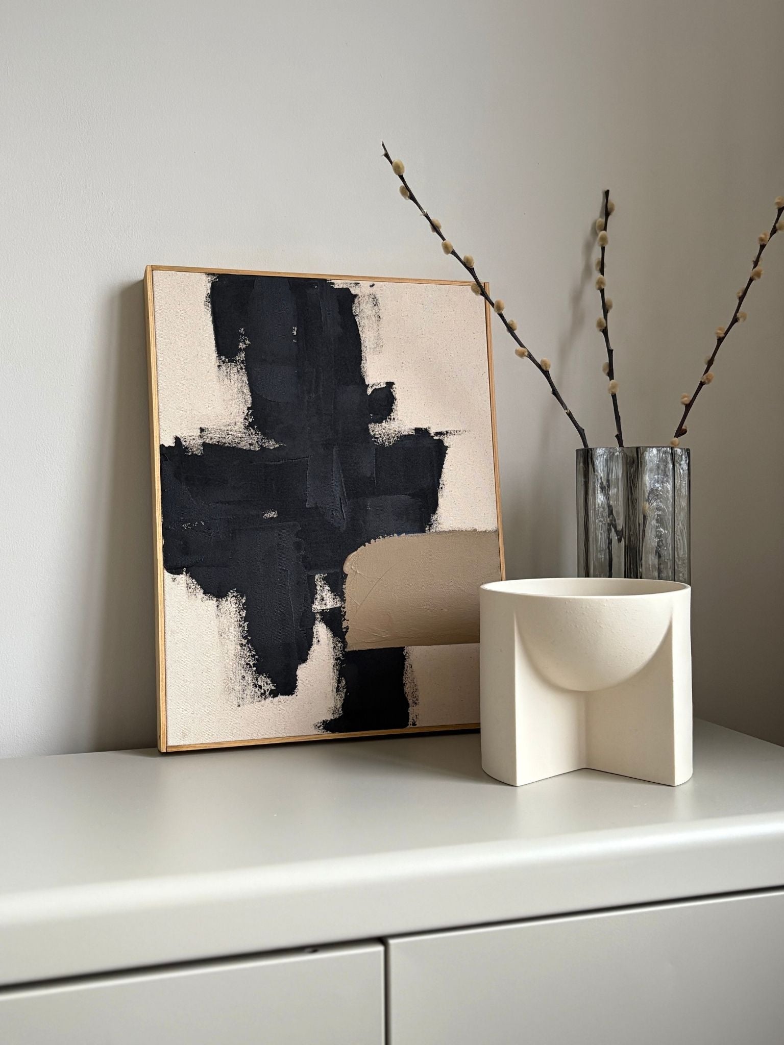 Handcrafted framed monochrome abstract painting on cotton canvas with oak edge frame, created using Plan’s monochrome palette with expressive black and beige marks and raw texture, styled as minimalist home decor.