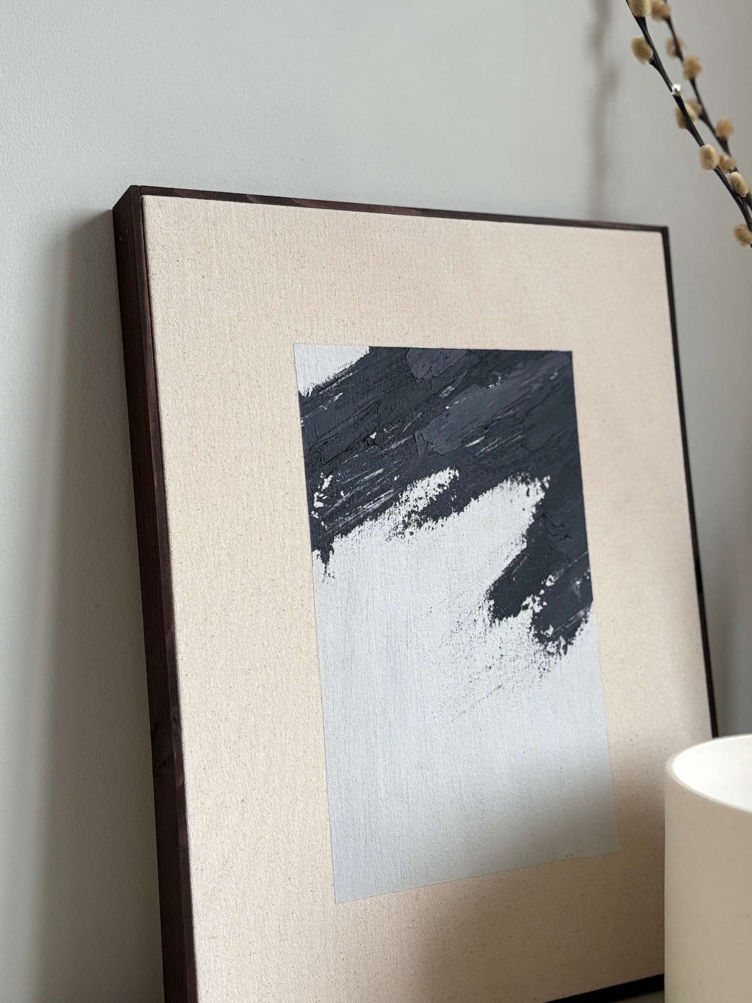 Finished framed canvas artwork in monochrome tones, featuring expressive black brush marks on natural cotton canvas, styled on a sideboard with sculptural décor.