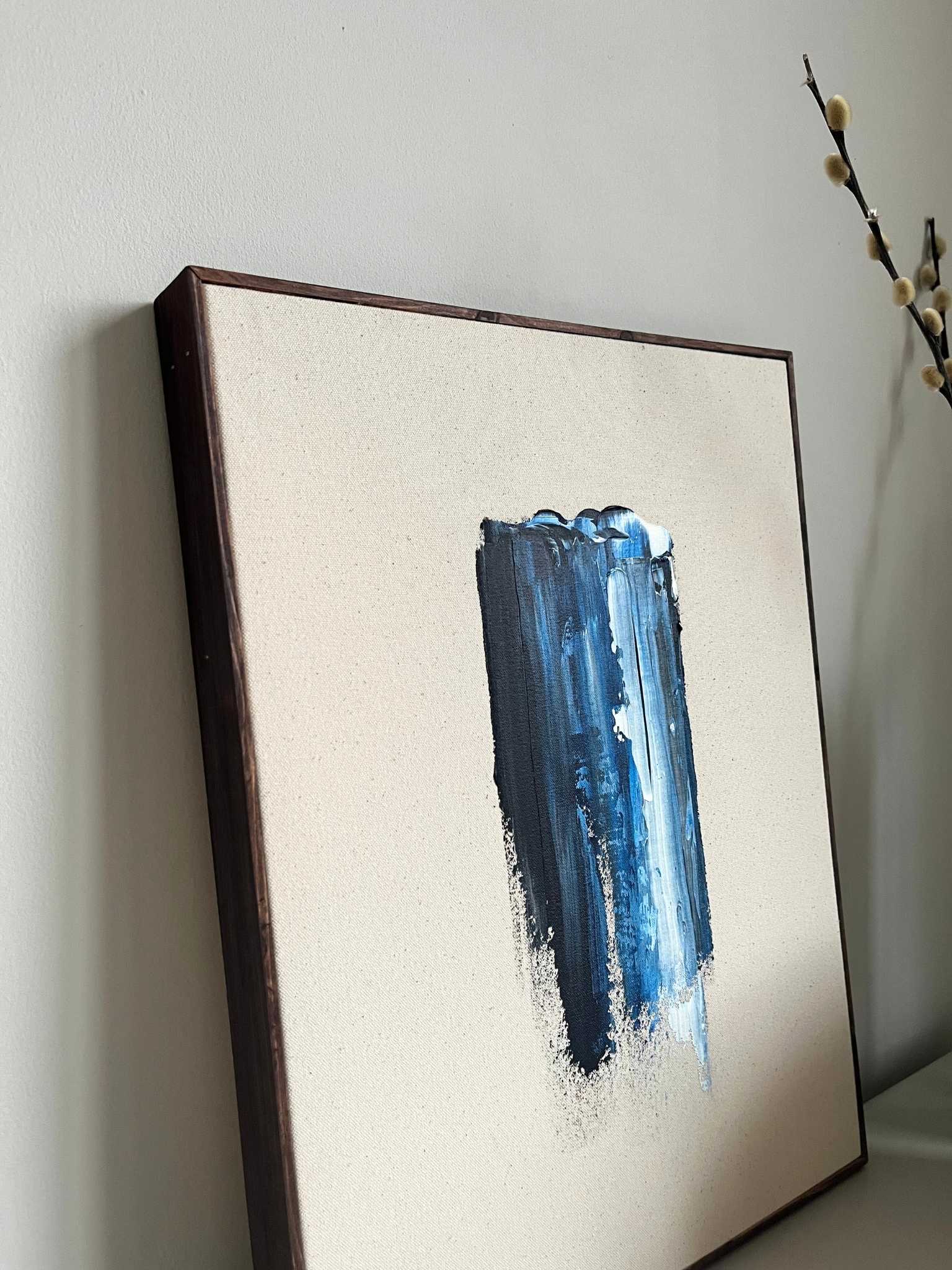 Finished framed abstract canvas artwork created with Plan’s Navy & Bright palette, featuring a bold vertical navy brushstroke on raw canvas with dark oak edge frame, styled on a minimalist surface with sculptural decor.
