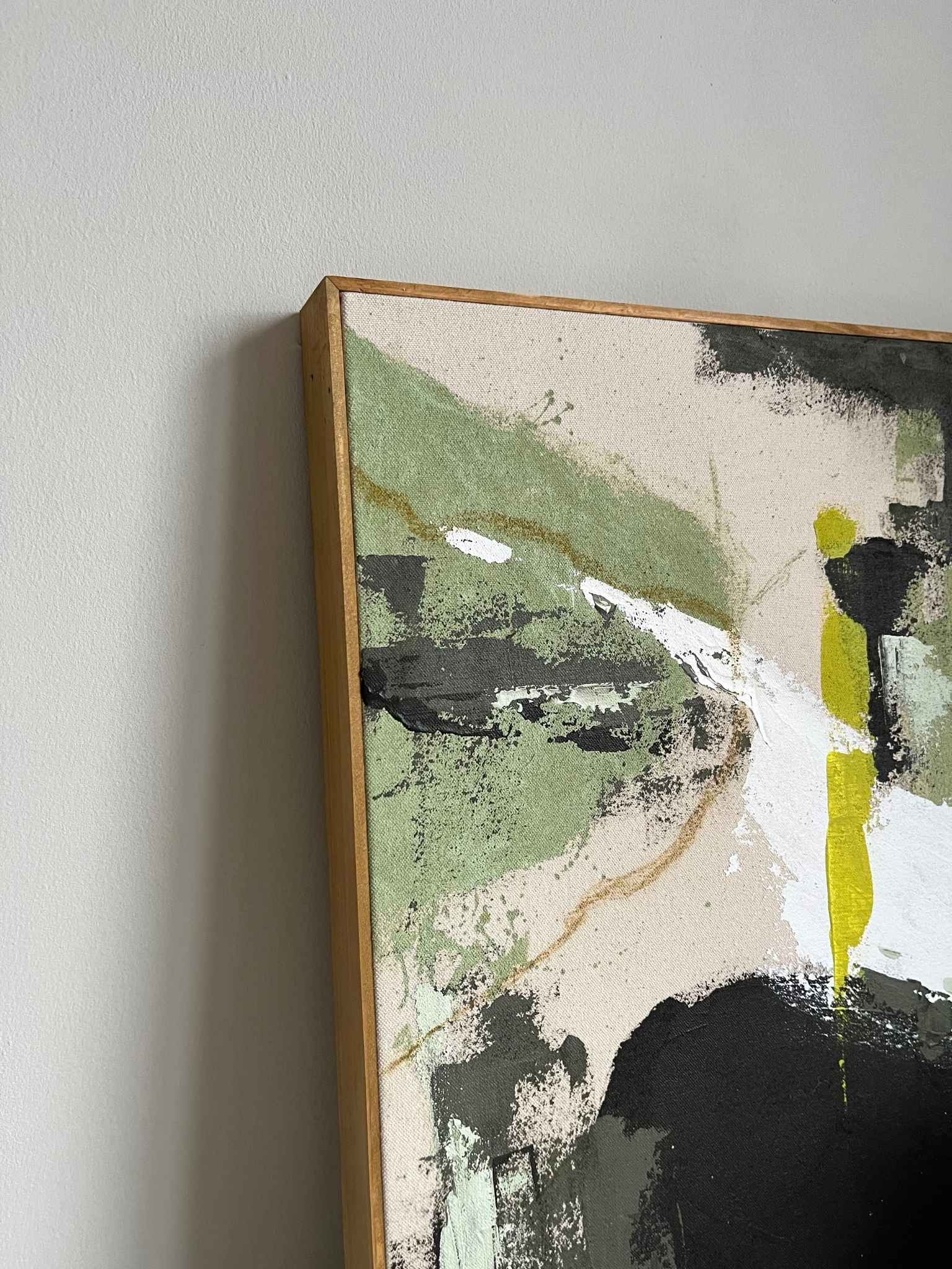Finished abstract framed canvas artwork created with the Plan Olive palette, showcasing soft olive green, muted black, beige and white brushstrokes on raw cotton canvas, finished with a handcrafted oak edge frame.