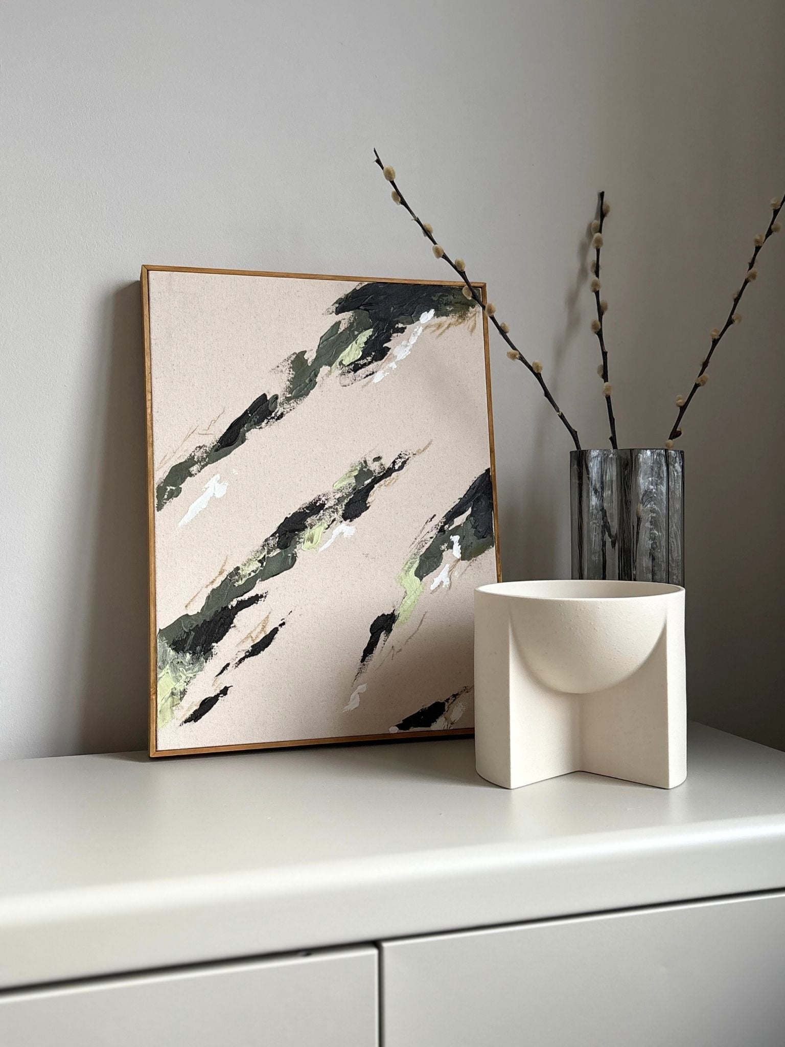 Modern abstract framed canvas artwork created from the Plan Olive colour palette, with layered brushstrokes in soft green, black and white on raw cotton canvas, finished with a handcrafted oak edge frame.