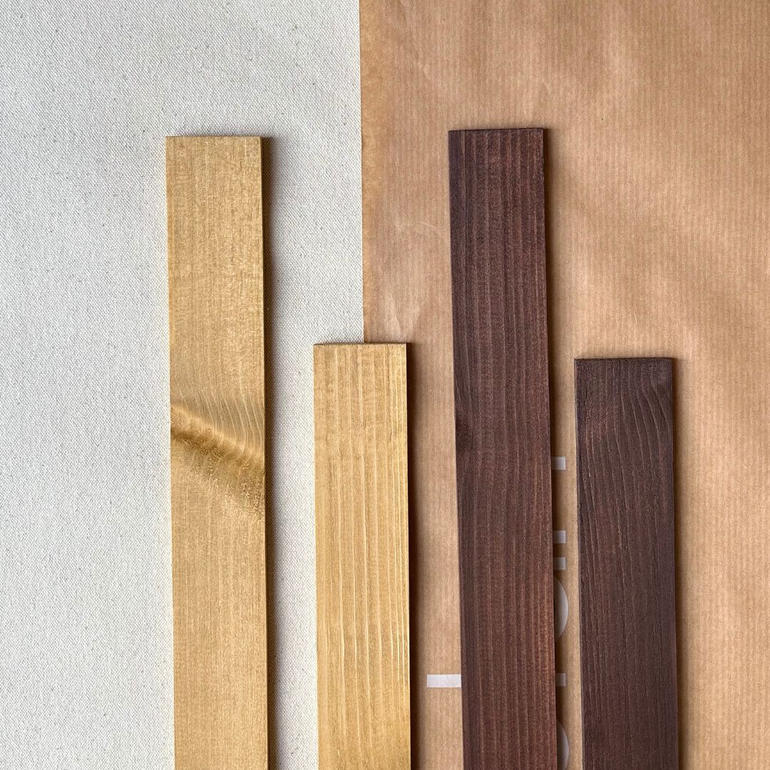 Two sets of handcrafted and hand-stained oak and dark oak edge frames prepared for framing canvas artworks in DIY art kits.