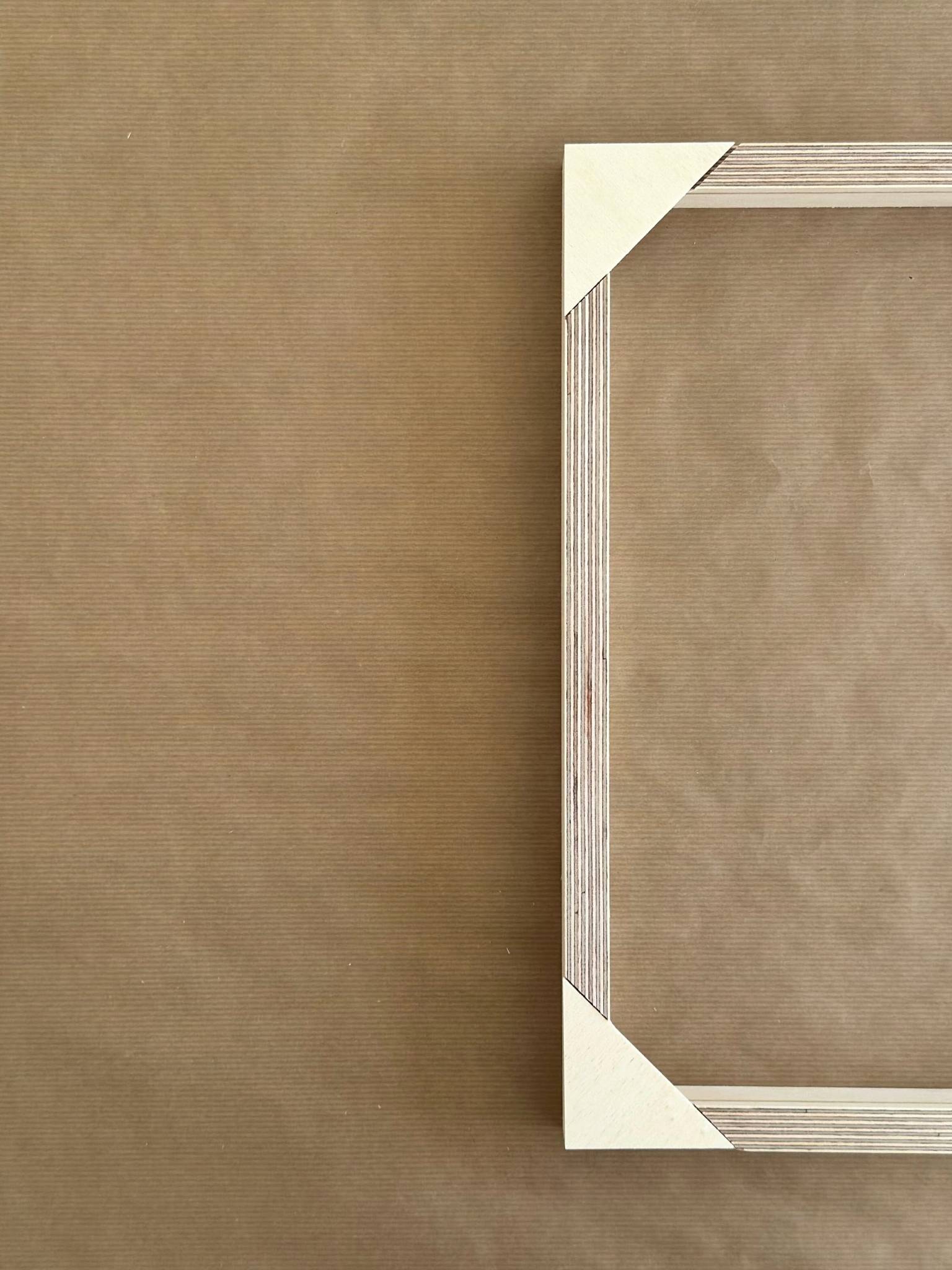 Close-up of a wooden inner frame corner from a DIY framed canvas art kit by Plan, showing precision-cut joints and frame construction detail