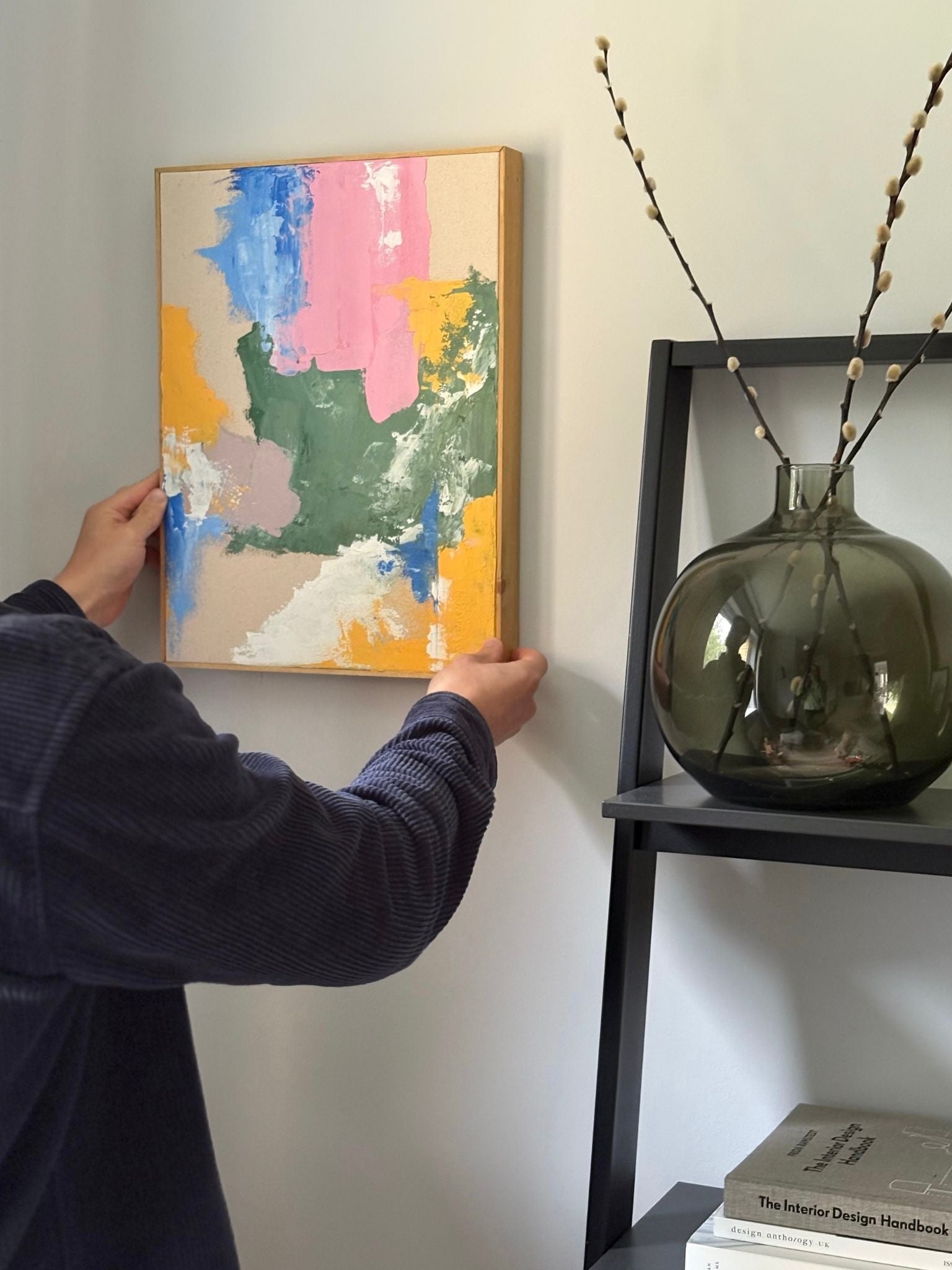 Finished abstract artwork created with a primary colours DIY framed canvas art kit, featuring layered brushstrokes in blue, pink, yellow and green on cotton canvas, framed in a handcrafted wooden oak edge frame.