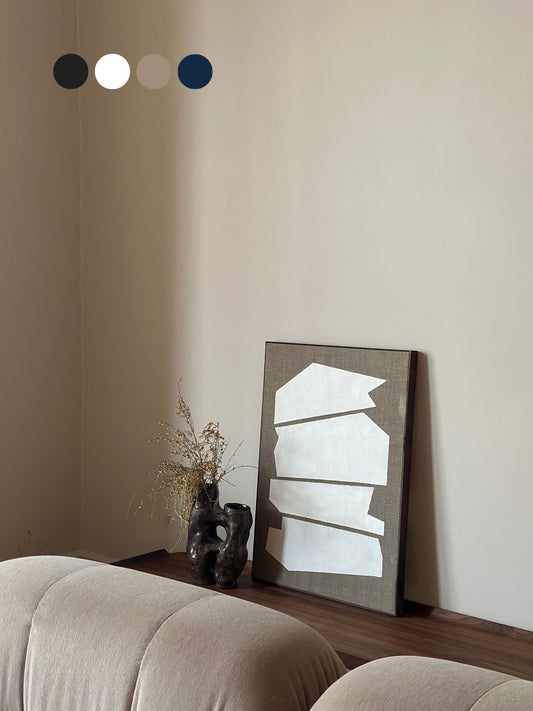 Monochrome framed linen canvas artwork leaning on a bench, featuring white geometric shapes on raw linen canvas, styled with ceramic vase and soft furnishings.