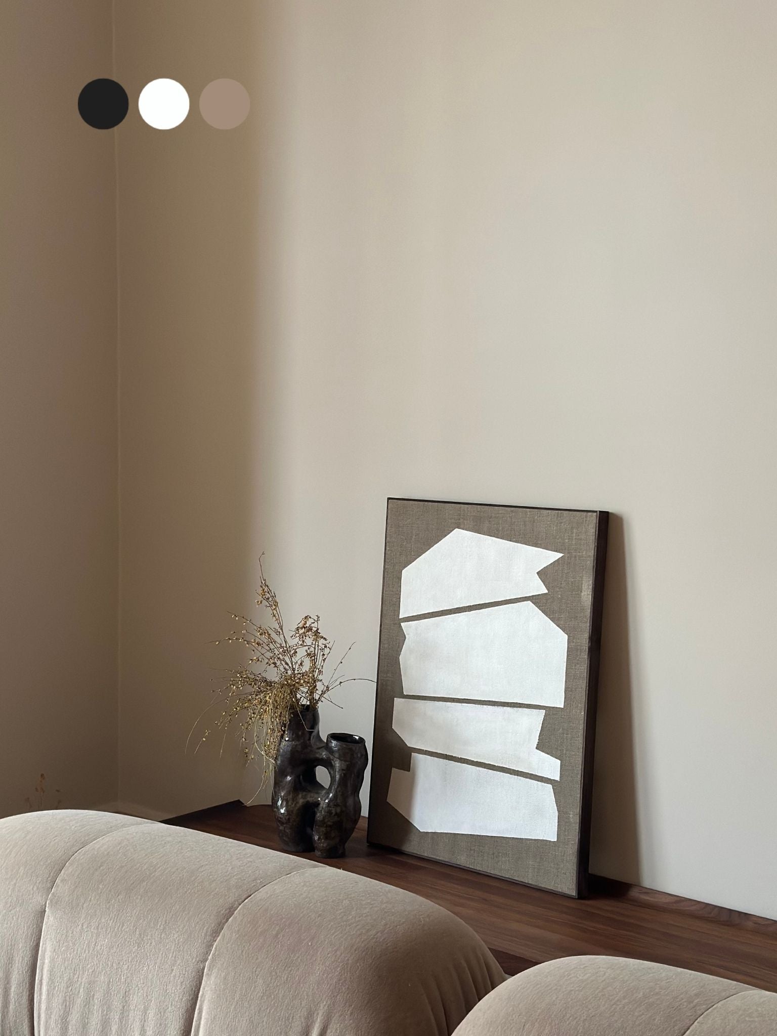 Monochrome framed linen canvas artwork leaning on a bench, featuring white geometric shapes on raw linen canvas, styled with ceramic vase and soft furnishings.