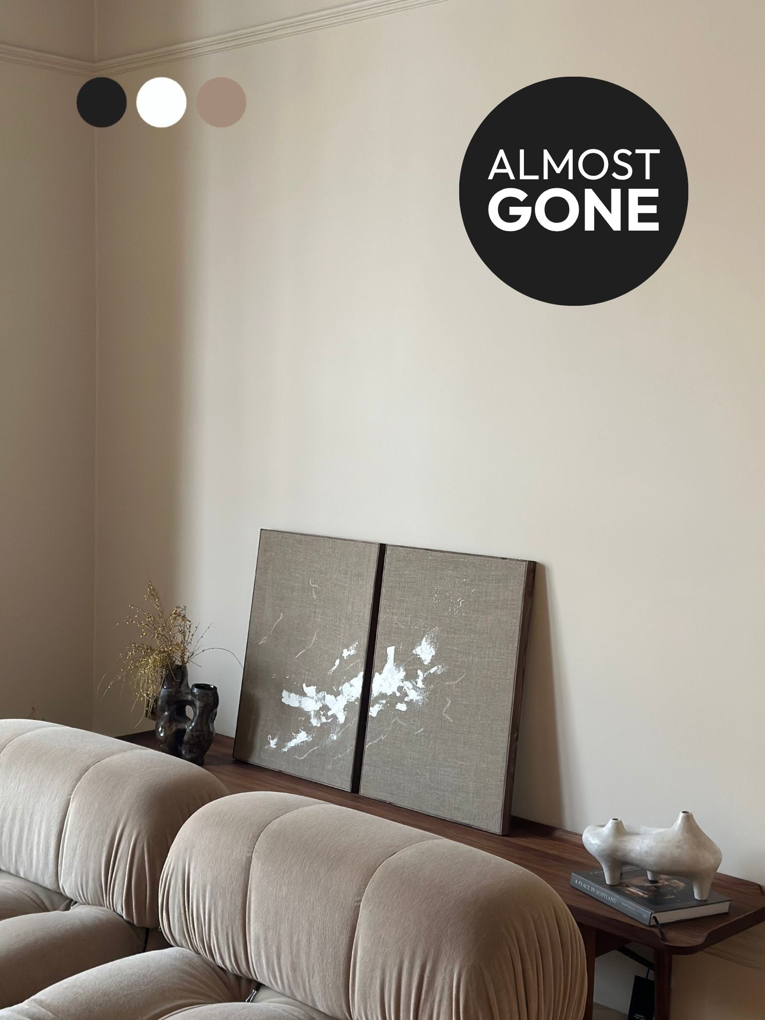 Two finished monochrome linen framed canvases with expressive white brushstrokes, styled on a wooden console in a neutral living room