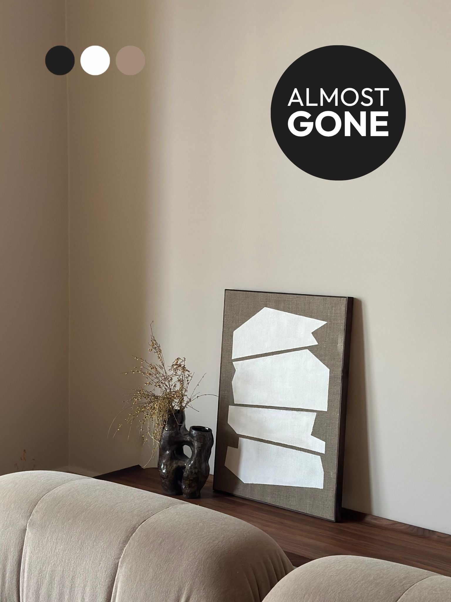 Monochrome framed linen canvas artwork leaning on a bench, featuring white geometric shapes on raw linen canvas, styled with ceramic vase and soft furnishings.