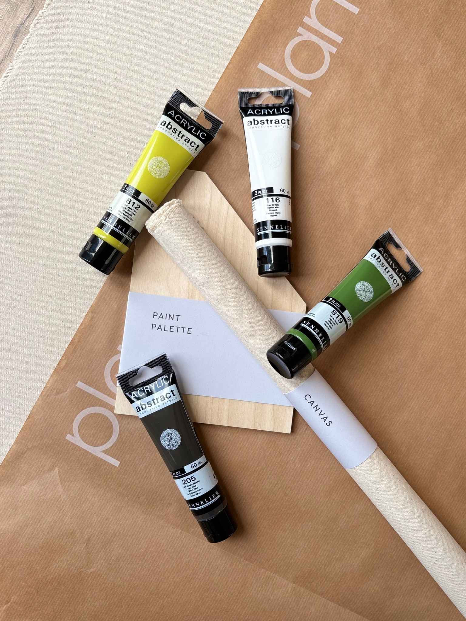 Olive colour palette from a DIY framed canvas art kit, showing green and neutral acrylic paints, rolled canvas and wooden paint palette. A complete at-home art kit for creating calm, nature-inspired abstract artwork.