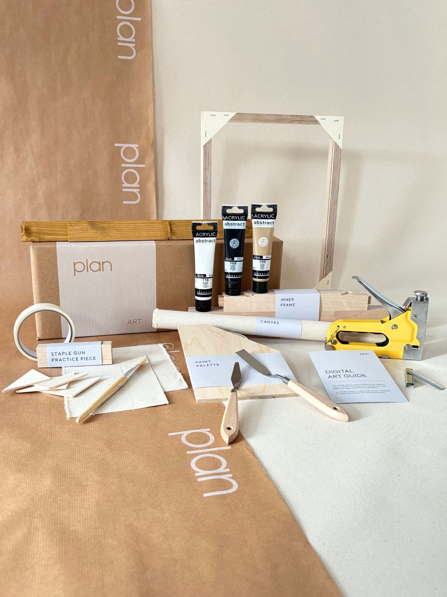 Monochrome abstract framed canvas artwork featuring expressive black brushstrokes on beige cotton canvas, styled in a calm dining space with candles and wooden furniture.