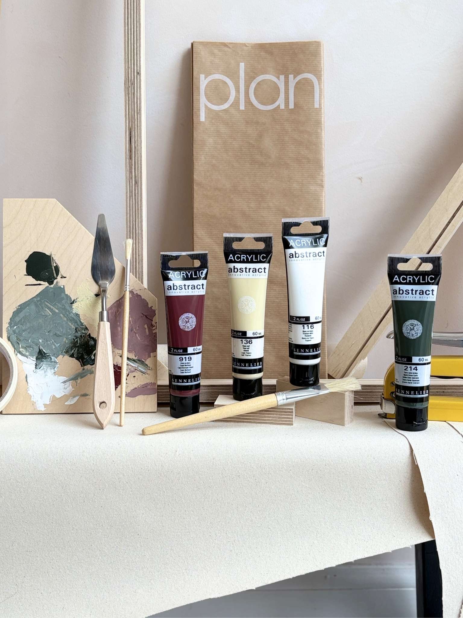 DIY framed canvas art kit with Forest Red acrylic paint palette, artist tools, canvas fabric, wooden frame pieces and Plan packaging.