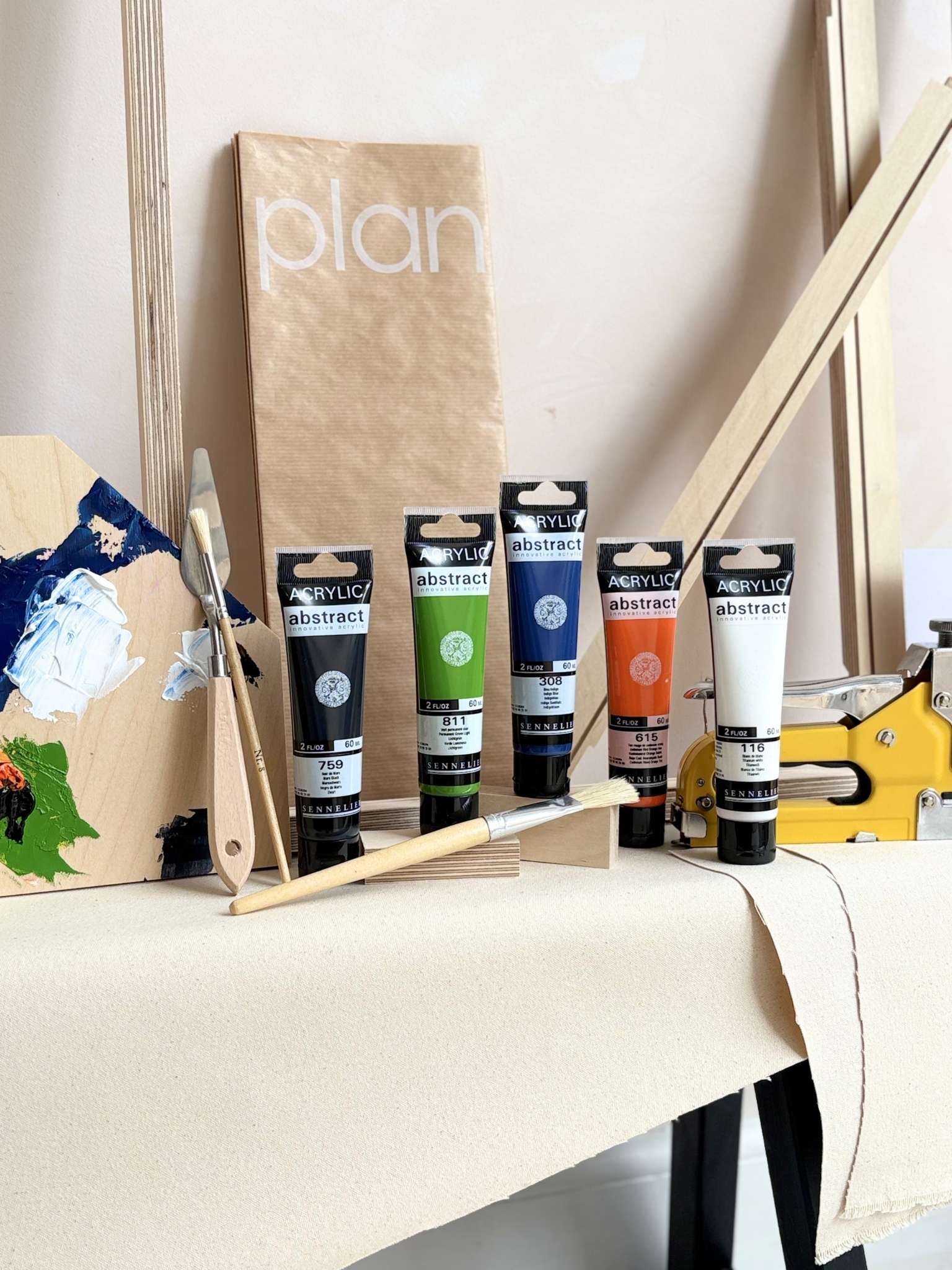 DIY framed canvas art kit with Navy colour palette and contrast accent colours, acrylic paints, paintbrush, canvas fabric and wooden frame pieces.