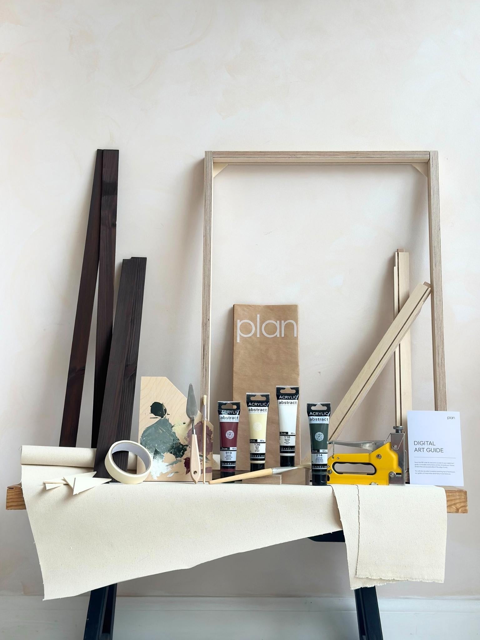 Forest Red framed canvas art kit by Plan, medium 50 x 70 cm size with dark oak edge frame, showing frame, cotton canvas, acrylic paints and art tools.
