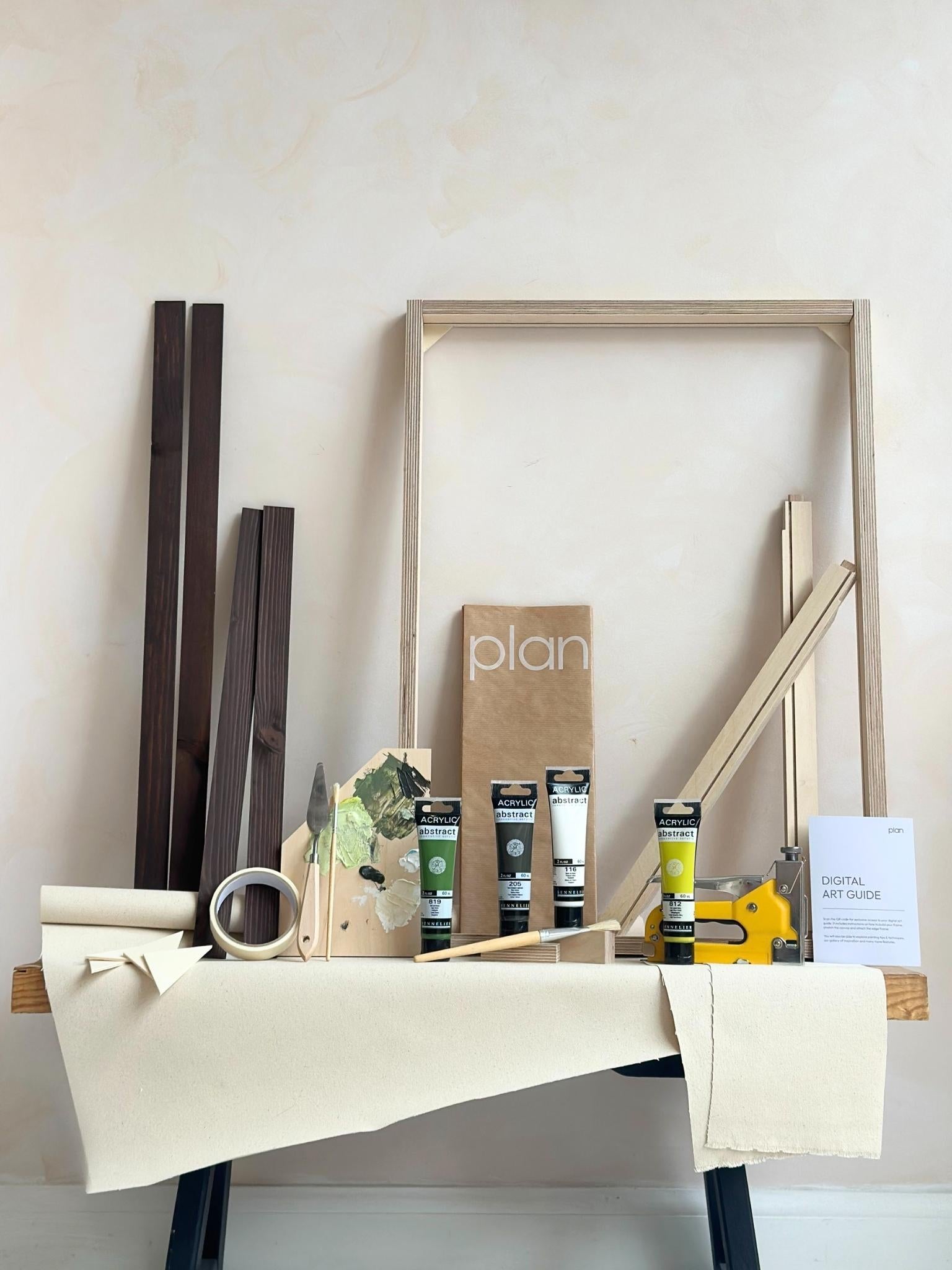 Olive framed canvas art kit by Plan, medium 50 x 70 cm size with dark oak edge frame, showing frame, cotton canvas, acrylic paints and art tools.