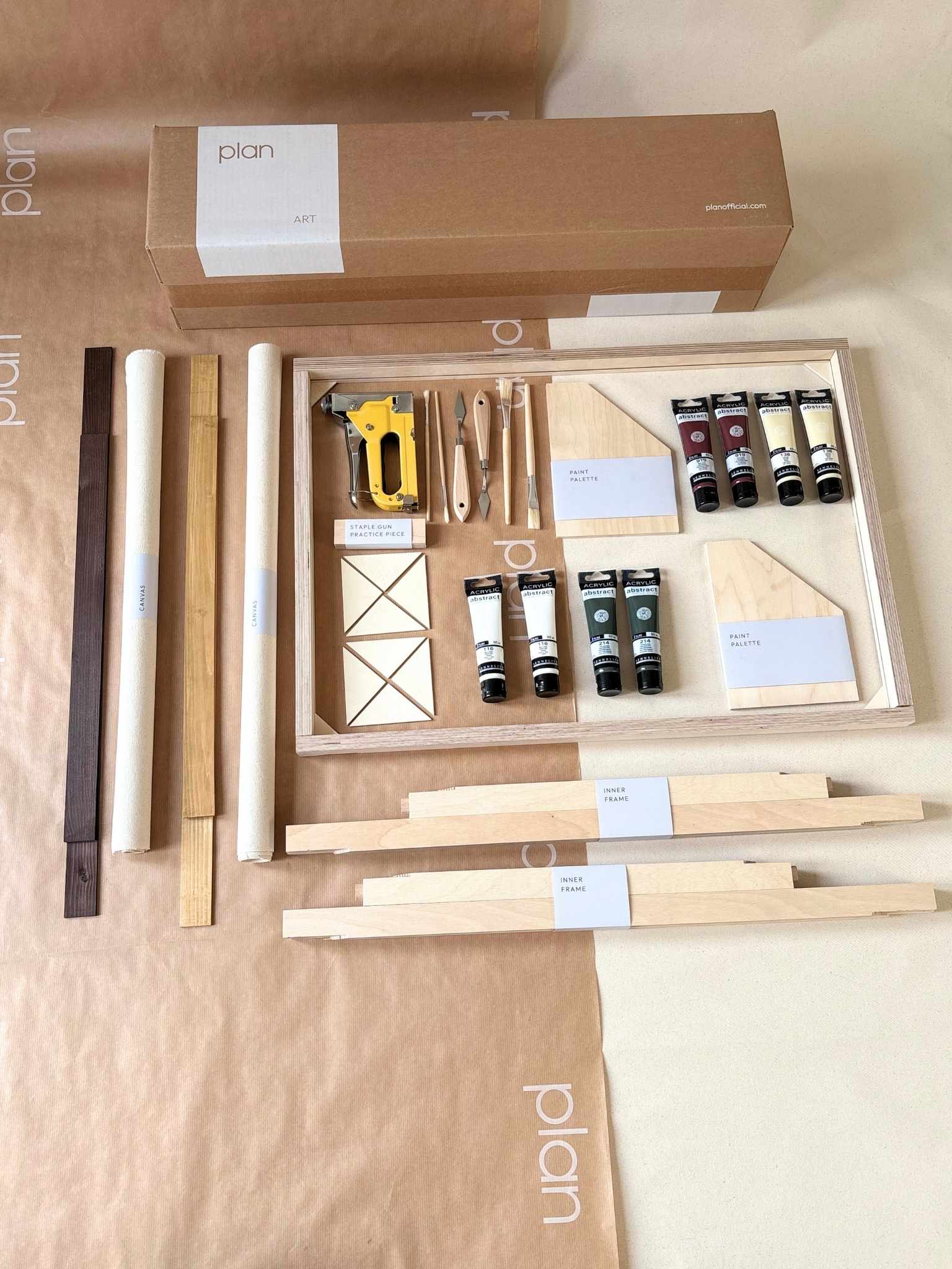 Everything you need to create two matching framed artworks at home, shown as a Forest Red double framed canvas art kit with mixed oak and dark oak frames, canvases, acrylic paints and professional art tools laid out flat