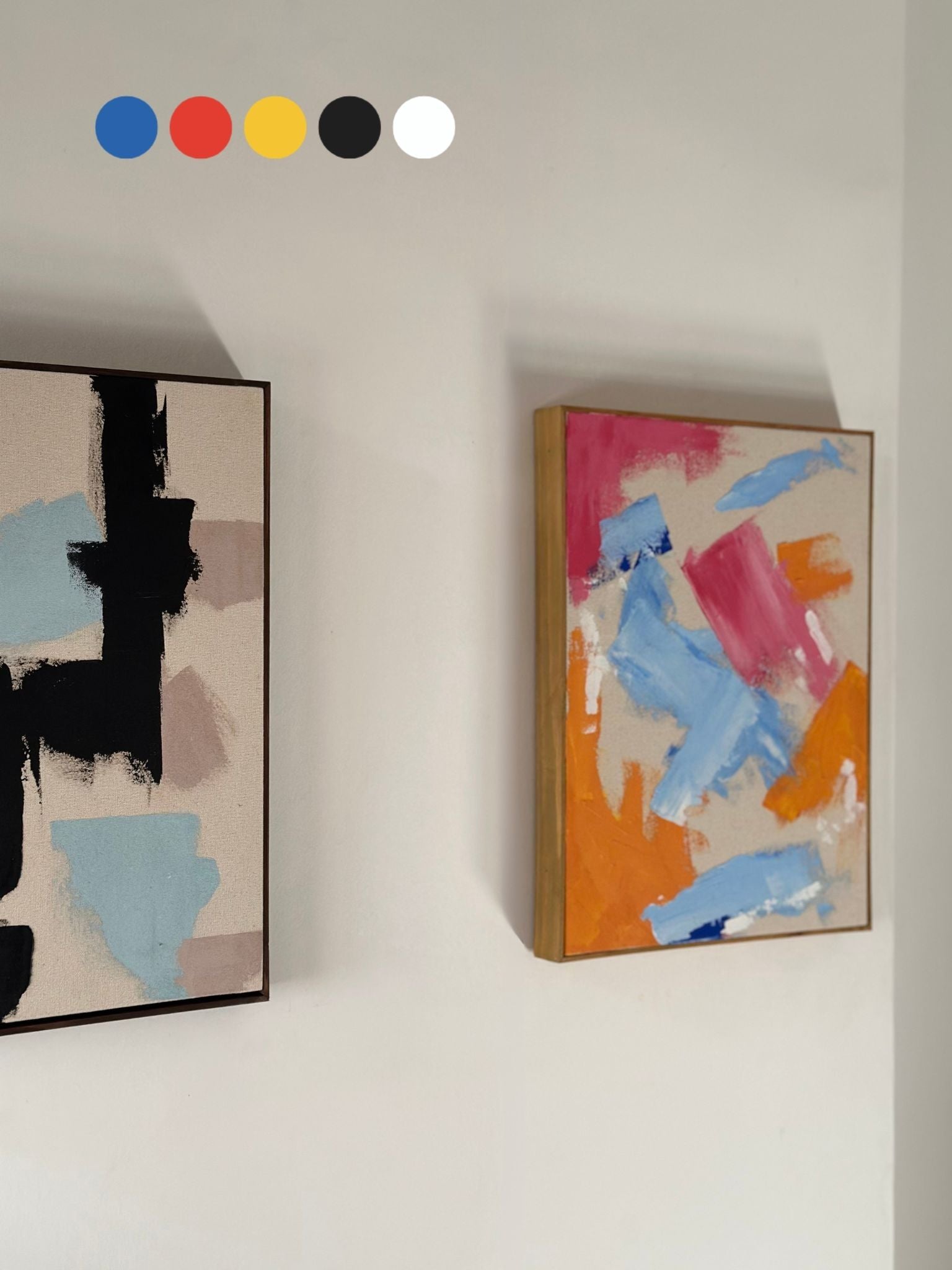 Two framed abstract artworks created with the MIX primary colours double art kit, featuring bold blue, red and yellow brushstrokes on raw cotton canvas with handcrafted oak and dark oak edge frames.