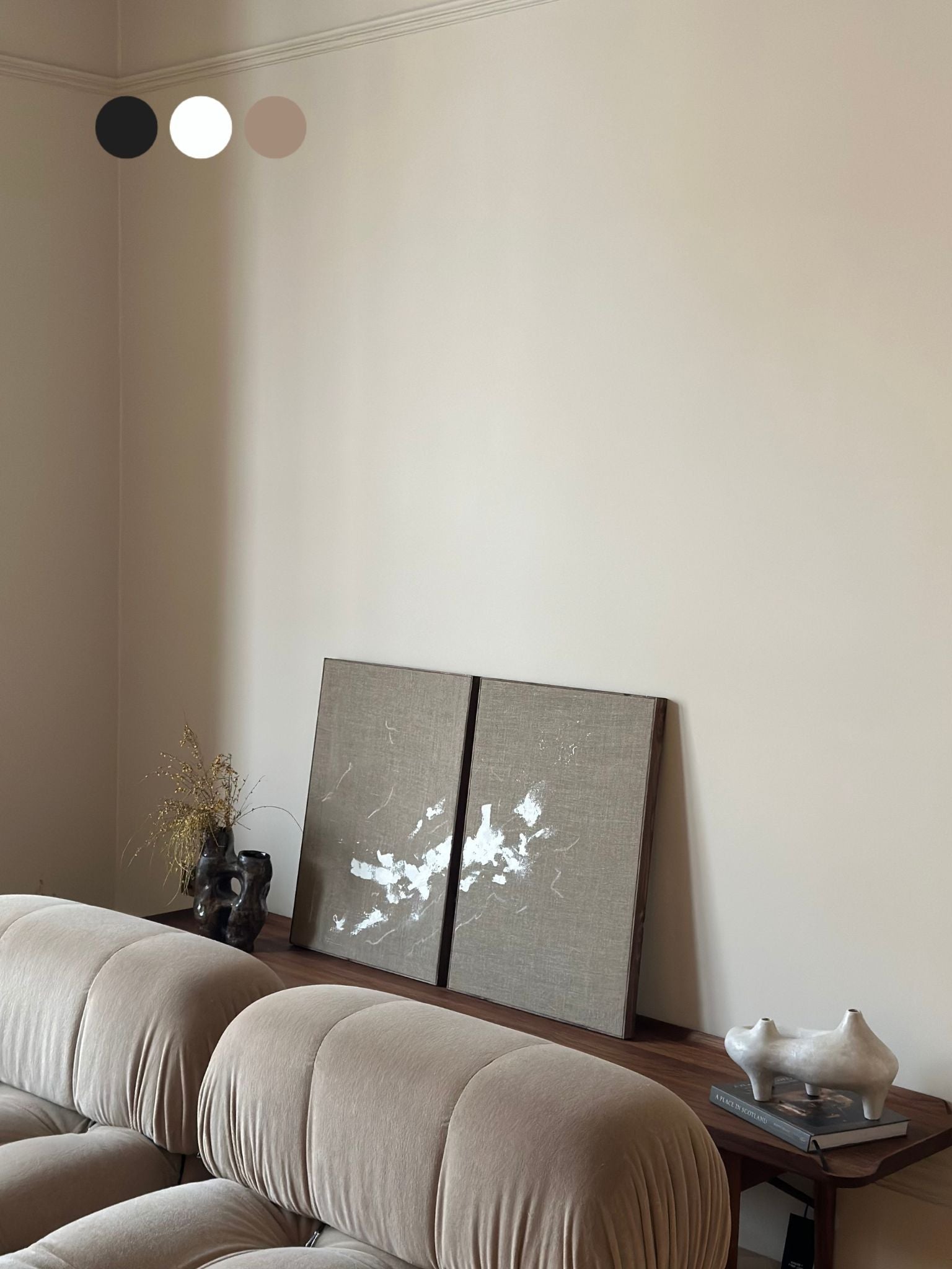 Two finished monochrome linen framed canvases with expressive white brushstrokes, styled on a wooden console in a neutral living room