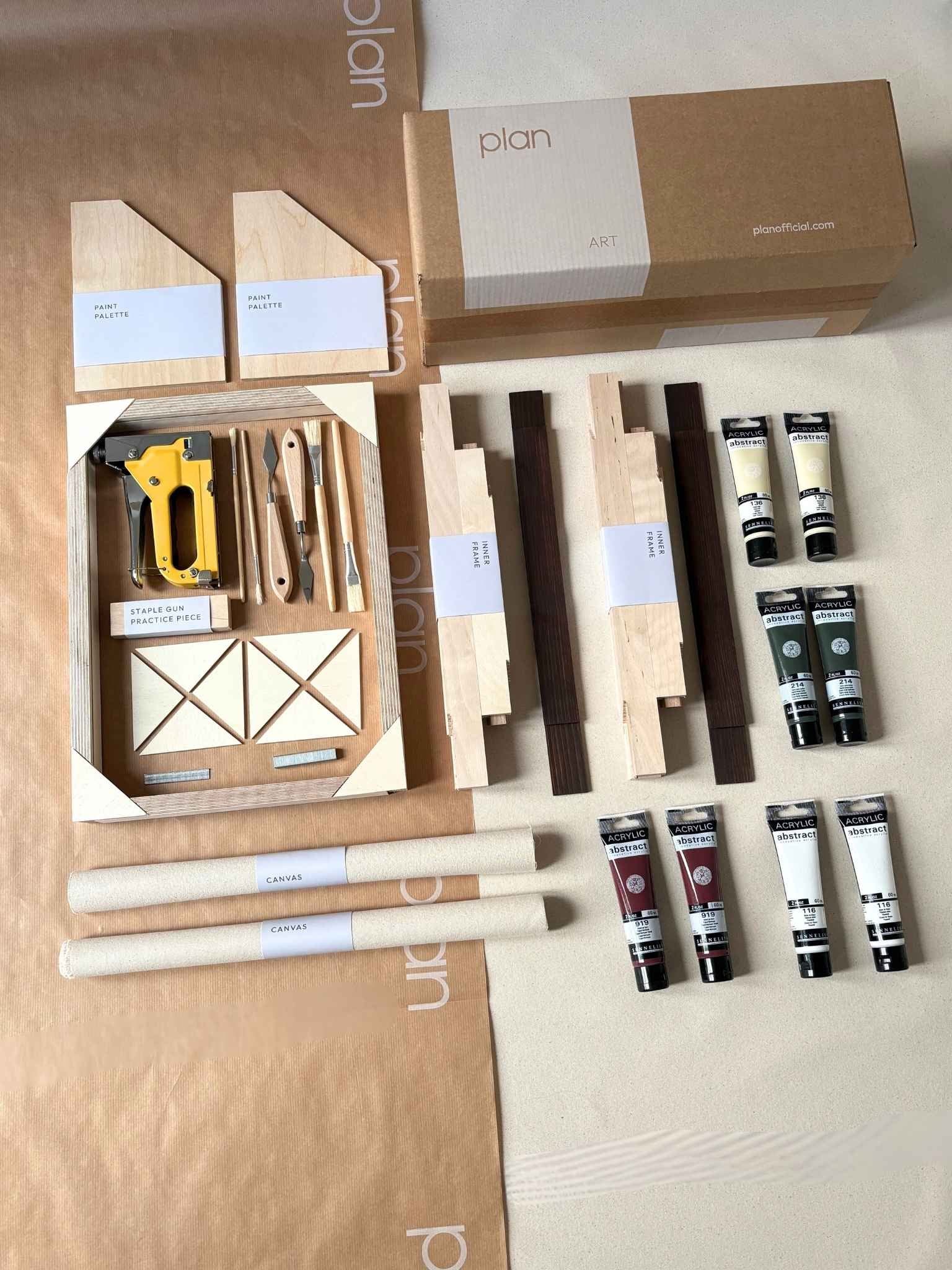 Everything you need to create your own framed artwork at home, shown as a Forest Red small double canvas art kit with dark oak frames, canvases, acrylic paints and painting tools laid out flat