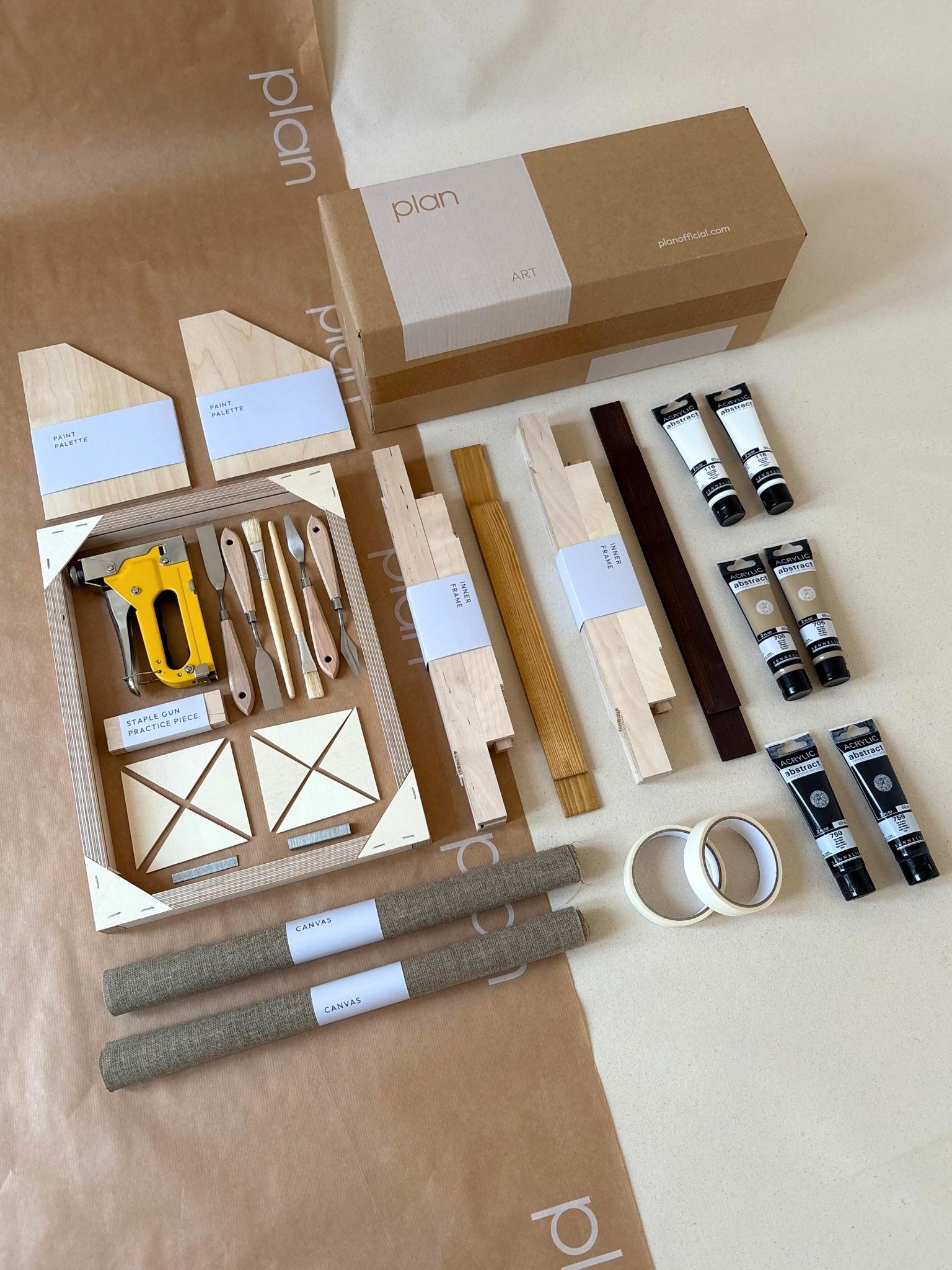 Two finished monochrome linen framed canvases with expressive white brushstrokes, styled on a wooden console in a neutral living room