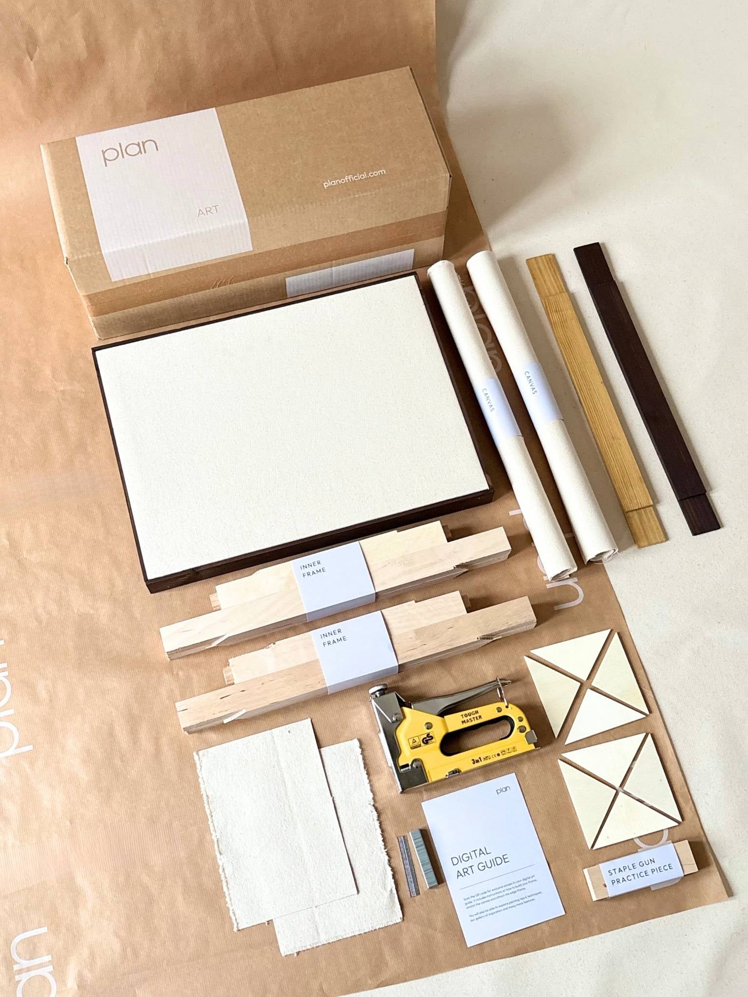 Blank framed cotton canvases from a DIY art kit styled leaning and hanging on a dining room wall with soft natural light.