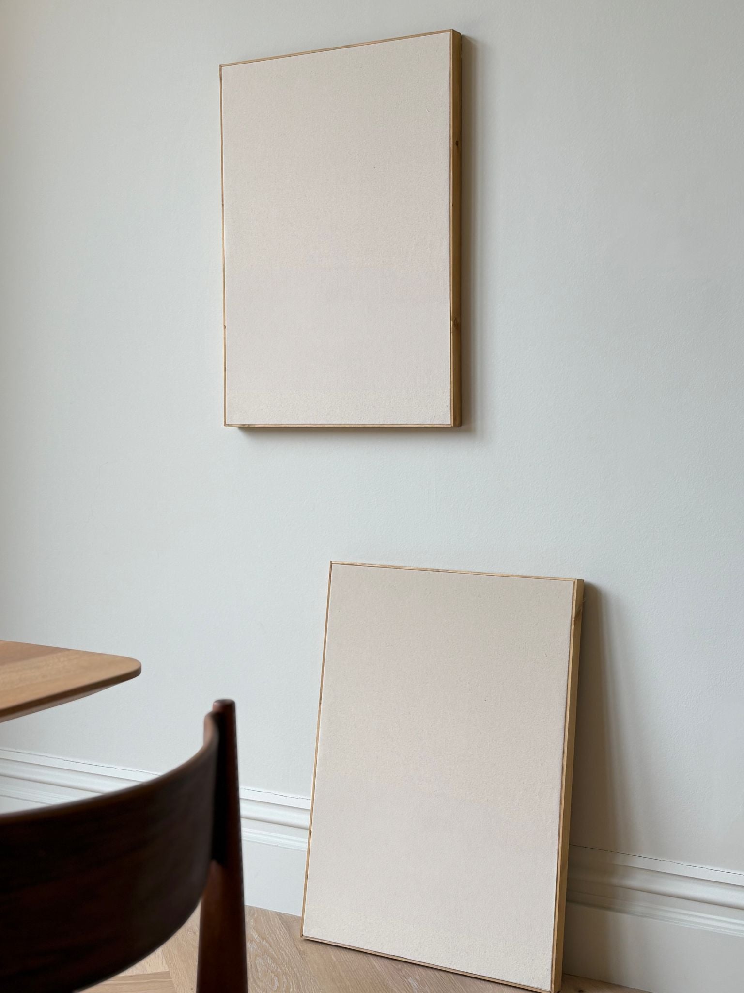 Blank framed cotton canvases from a DIY art kit styled leaning and hanging on a dining room wall with soft natural light.