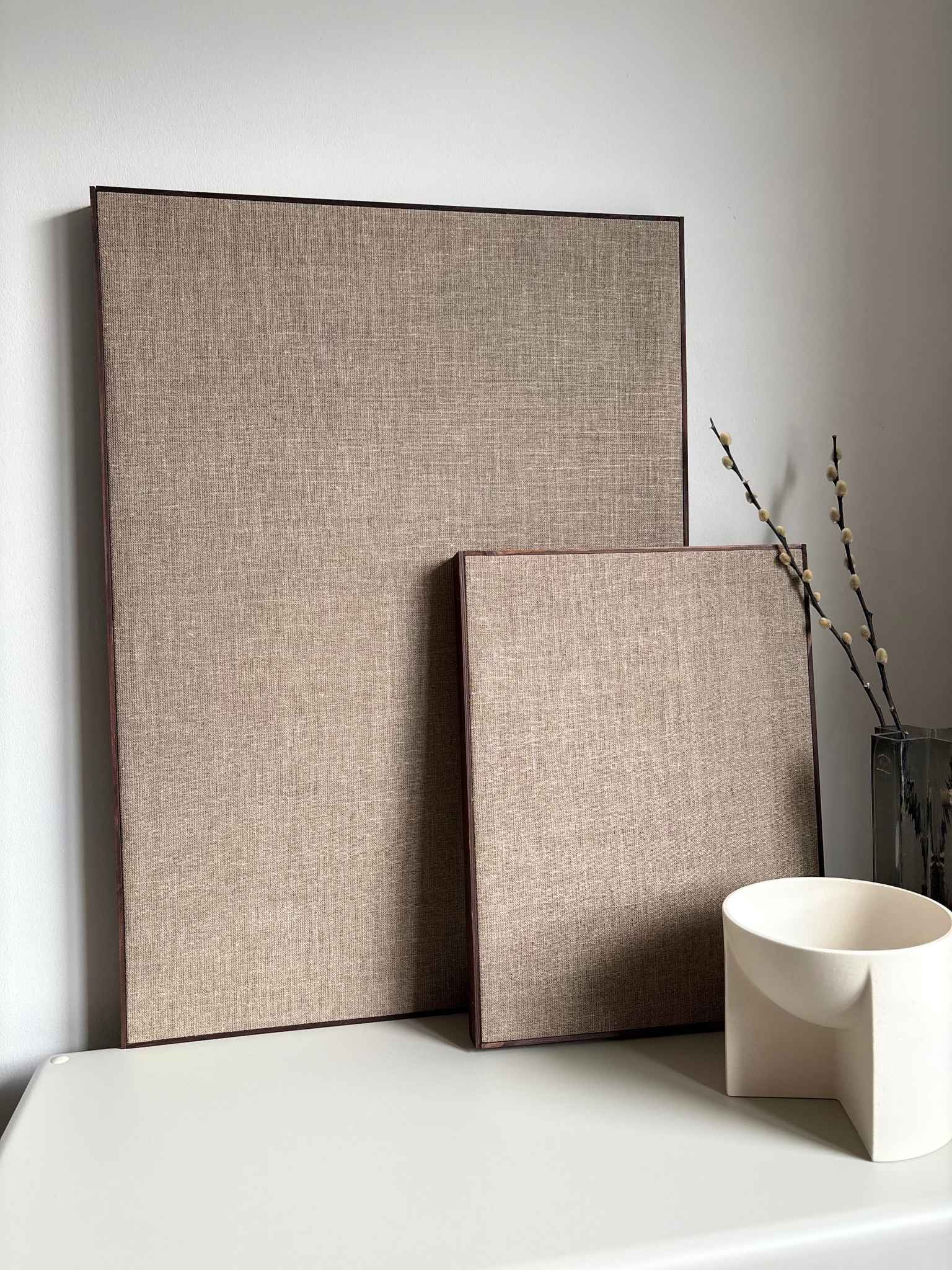 Framed linen canvases with dark oak edge frames styled with minimalist decor, highlighting the natural linen surface and gallery-style wooden frame
