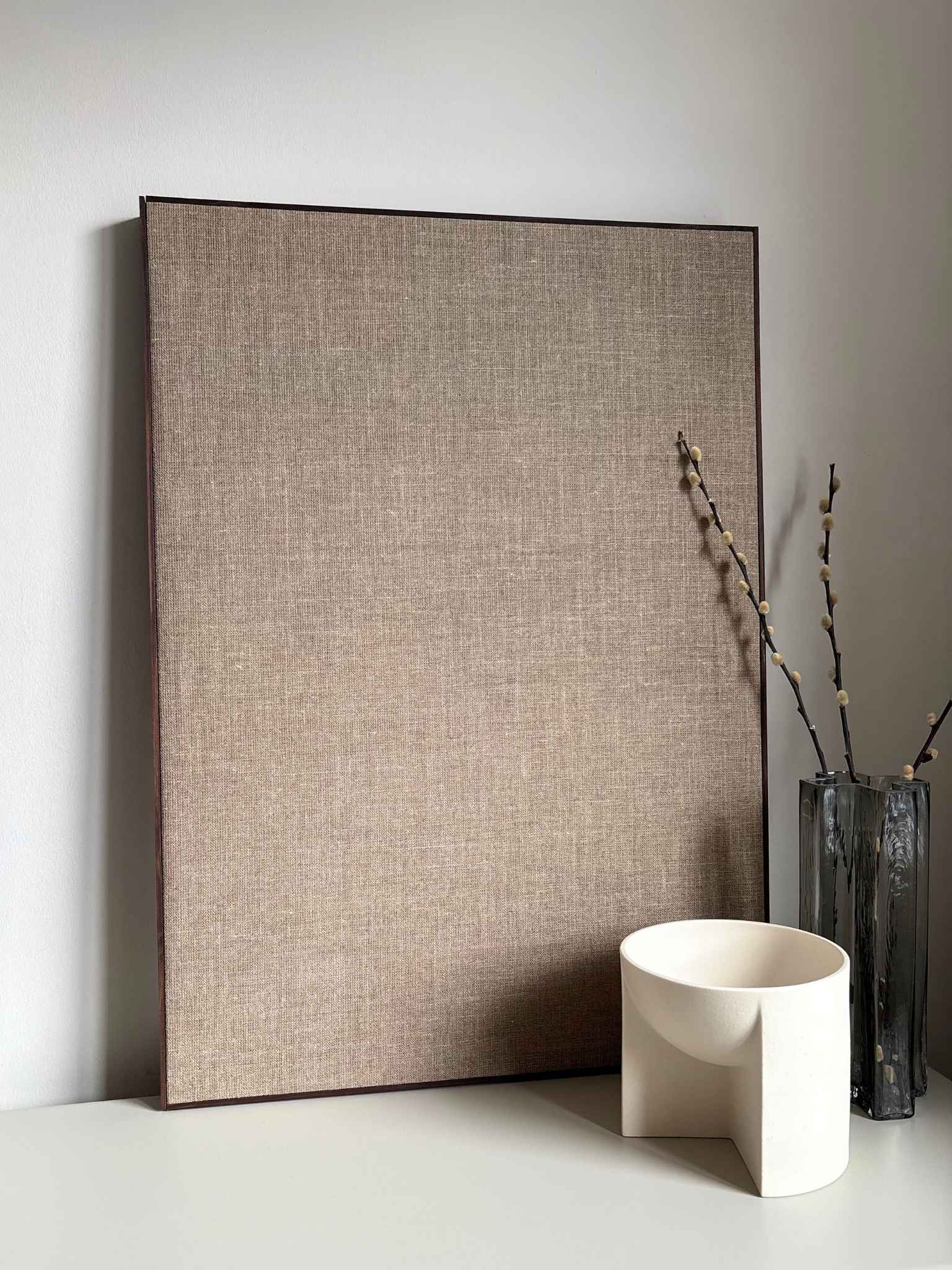 Large framed linen canvas artwork leaning against a wall, showcasing the sturdy construction and refined finish of the handmade wooden frame