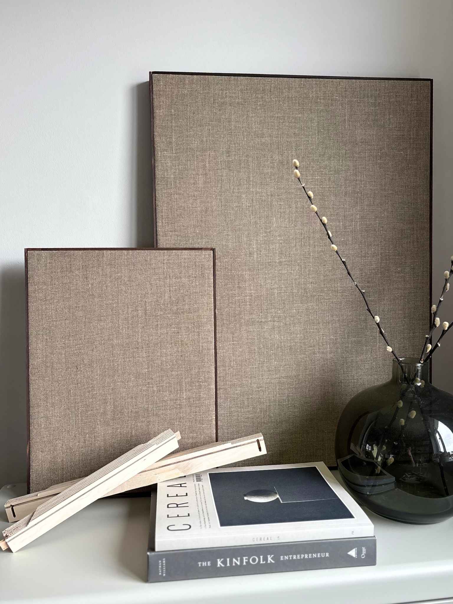 Finished framed linen canvases styled on a shelf, highlighting the solid wooden edge frame and natural linen texture from a DIY framed canvas kit