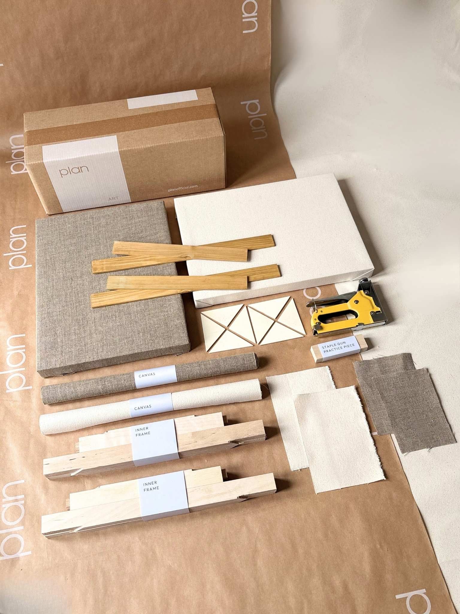 Small double DIY framed canvas art kit by Plan with oak edge frame, featuring blank mixed canvases, handcrafted inner frames, staple gun and all materials you need to build framed canvases neatly laid out on Plan branded paper.